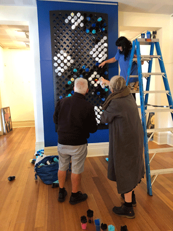 Ken and Lynne Makings with Backspace co-ordinator Melinda Muscat hanging Lynne's "Ginan..."